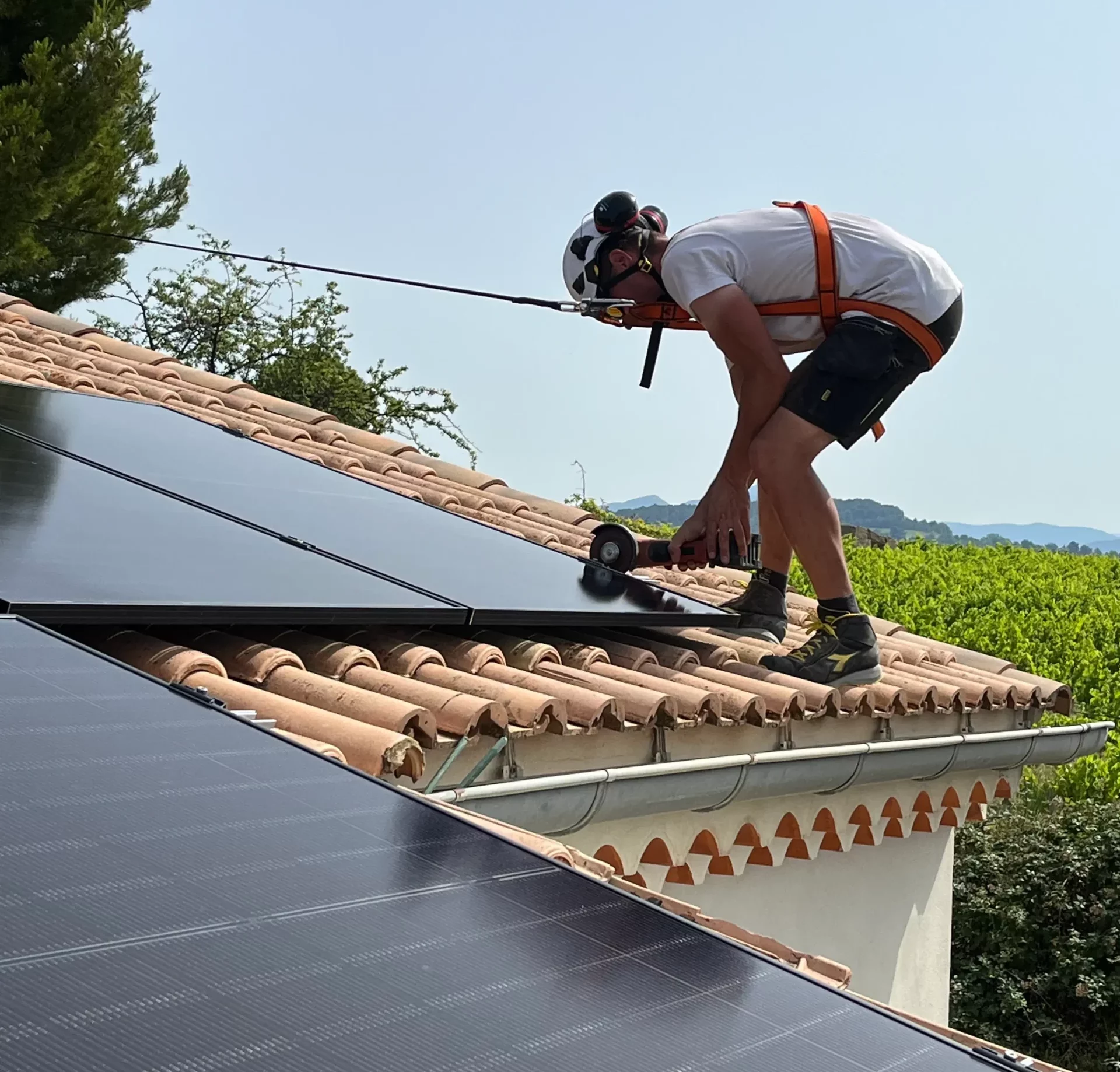 technicien sur le toit d'une maison pendant une installation photovoltaïque